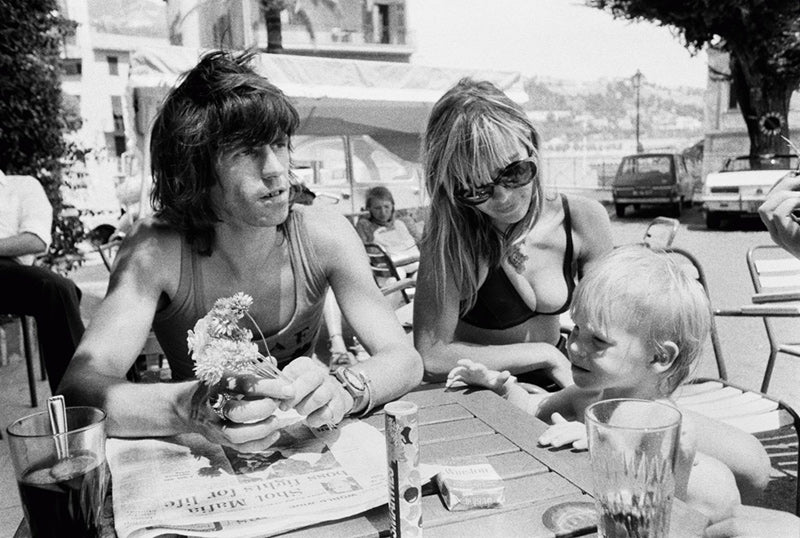 Keith Richards, Anita Pallenberg and their son Marlon at a cafe in France, photographed by Michael Cooper, 1971.