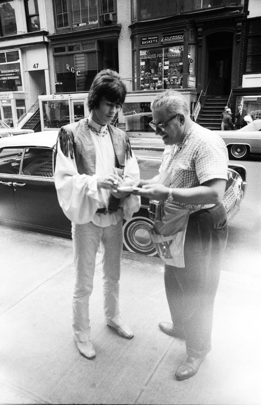 Keith Richards with a shopkeeper in New York, photographed by Michael Cooper, 1967.