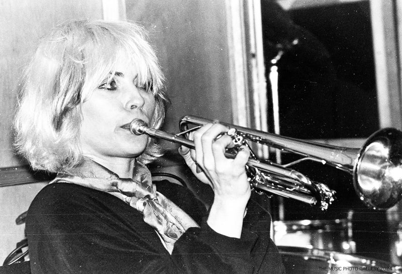 Debbie Harry playing trumpet onstage, photographed by Ebet Roberts.