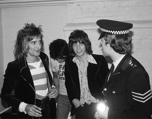 Rod Stewart, Mick Jagger and Ronnie Wood with the Police, 1975, photographed by Mick Rock.