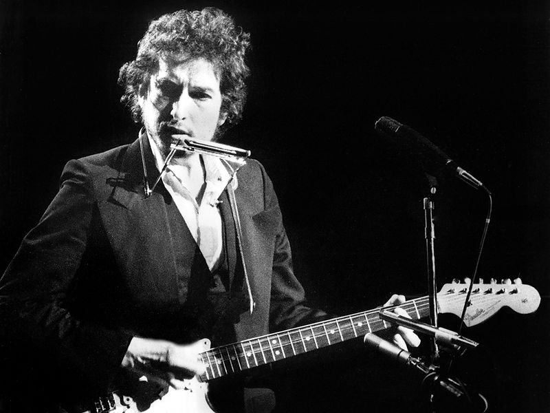 Bob Dylan performing with electric guitar and harmonica in 1974. Photograph by Gijsbert Hanekroot.