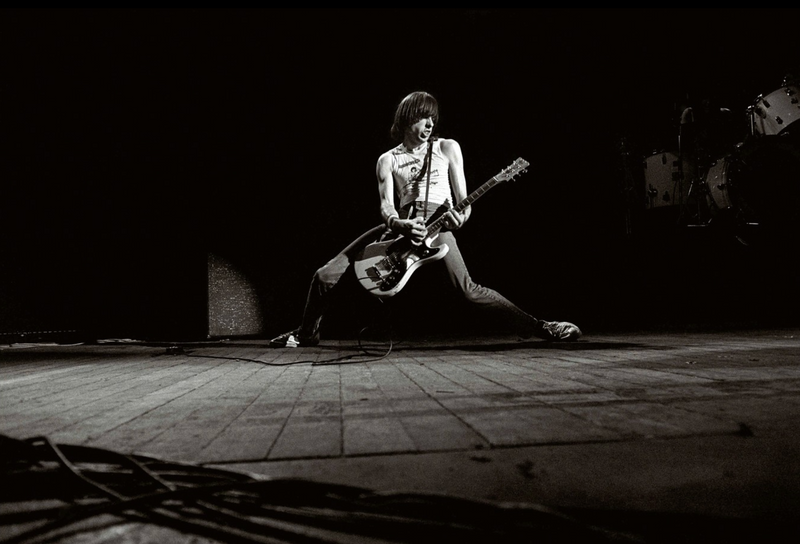 Johnny Ramone performing with his guitar at Hammersmith Odeon, London, in 1980, photographed by David Corio.