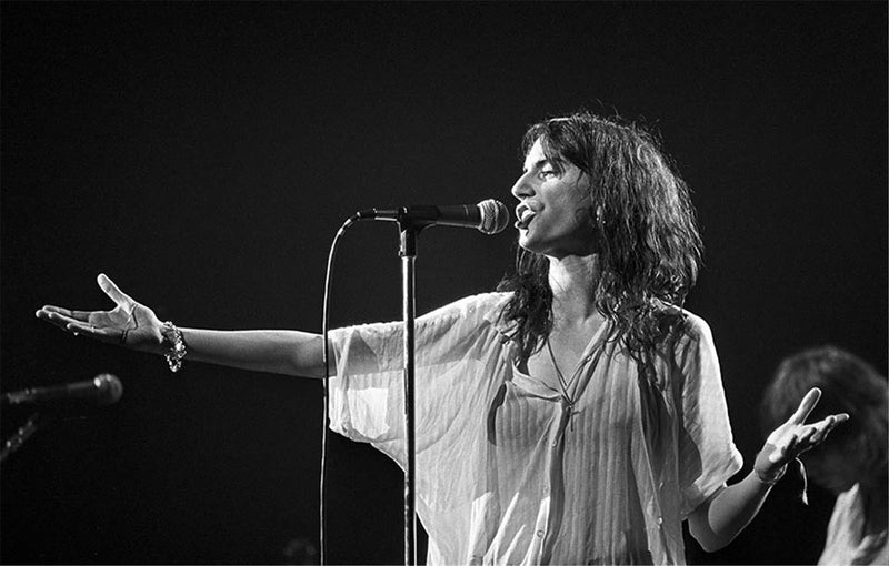 Patti Smith singing with open palms on stage, photographed by Charlyn Zlotnik, 1978.