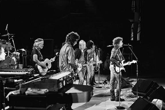 Willie Nelson, Tom Petty and Bob Dylan on stage at Farm Aid, photographed by Charlyn Zlotnik, 1985.