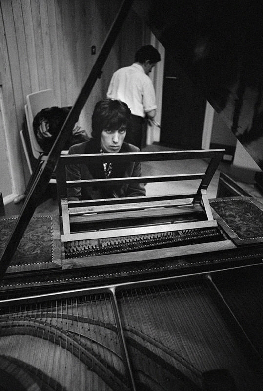 Bill Wyman of the Rolling Stones playing piano at Olympic Studios, London, photographed by Michael Cooper, 1966.