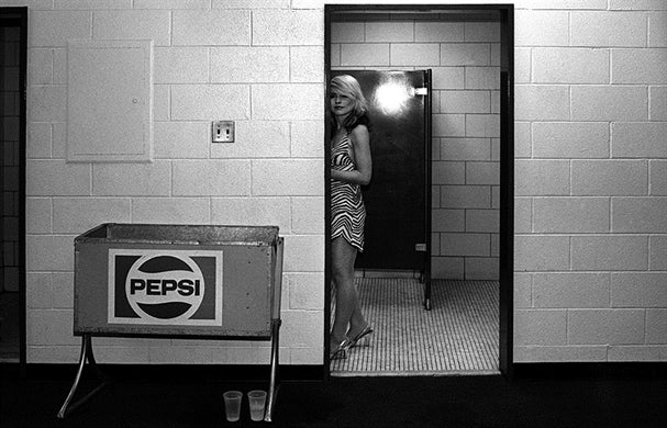 Debbie Harry framed in a doorway backstage beside a Pepsi crate, Philadelphia, black-and-white photograph by Martyn Goddard, 1978.