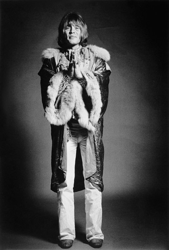Studio portrait of Brian Jones with hands together as if praying, photographed by Michael Cooper, 1969.