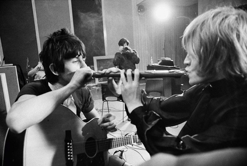 Keith Richards and Brian Jones fooling with a flute at Olympic Studios, London, photographed by Michael Cooper, 1966.