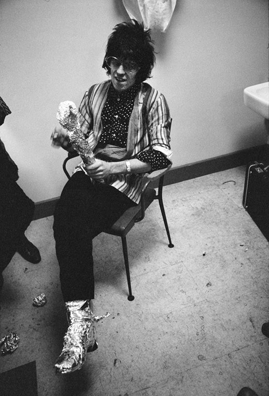 Keith Richards playing with a sheet of tin foil, London, photographed by Michael Cooper, 1967.