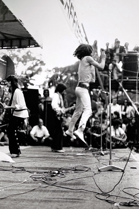 The Rolling Stones performing at Hyde Park with Mick Jagger mid-leap, London, photographed by Michael Cooper, 1969.