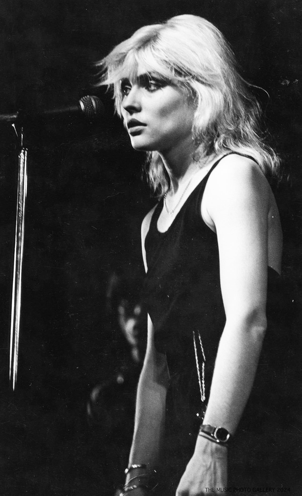 Debbie Harry onstage in a dark sleeveless top, photographed by Ebet Roberts.