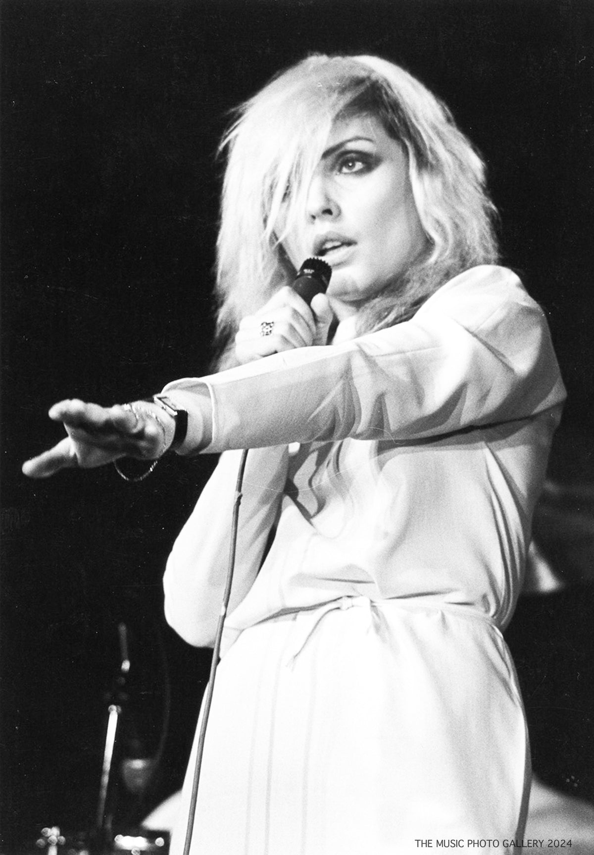 Debbie Harry reaching toward the audience during a performance, photographed by Ebet Roberts.