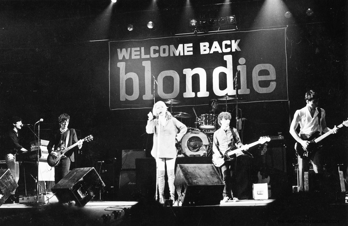 Blondie performing beneath a Welcome Back Blondie sign, photographed by Ebet Roberts.