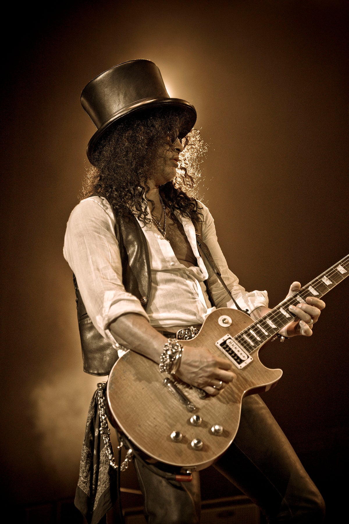 Sepia-toned image of Slash in a top hat at HP Pavilion, San Jose, California, 2011, photographed by Jérôme Brunet.