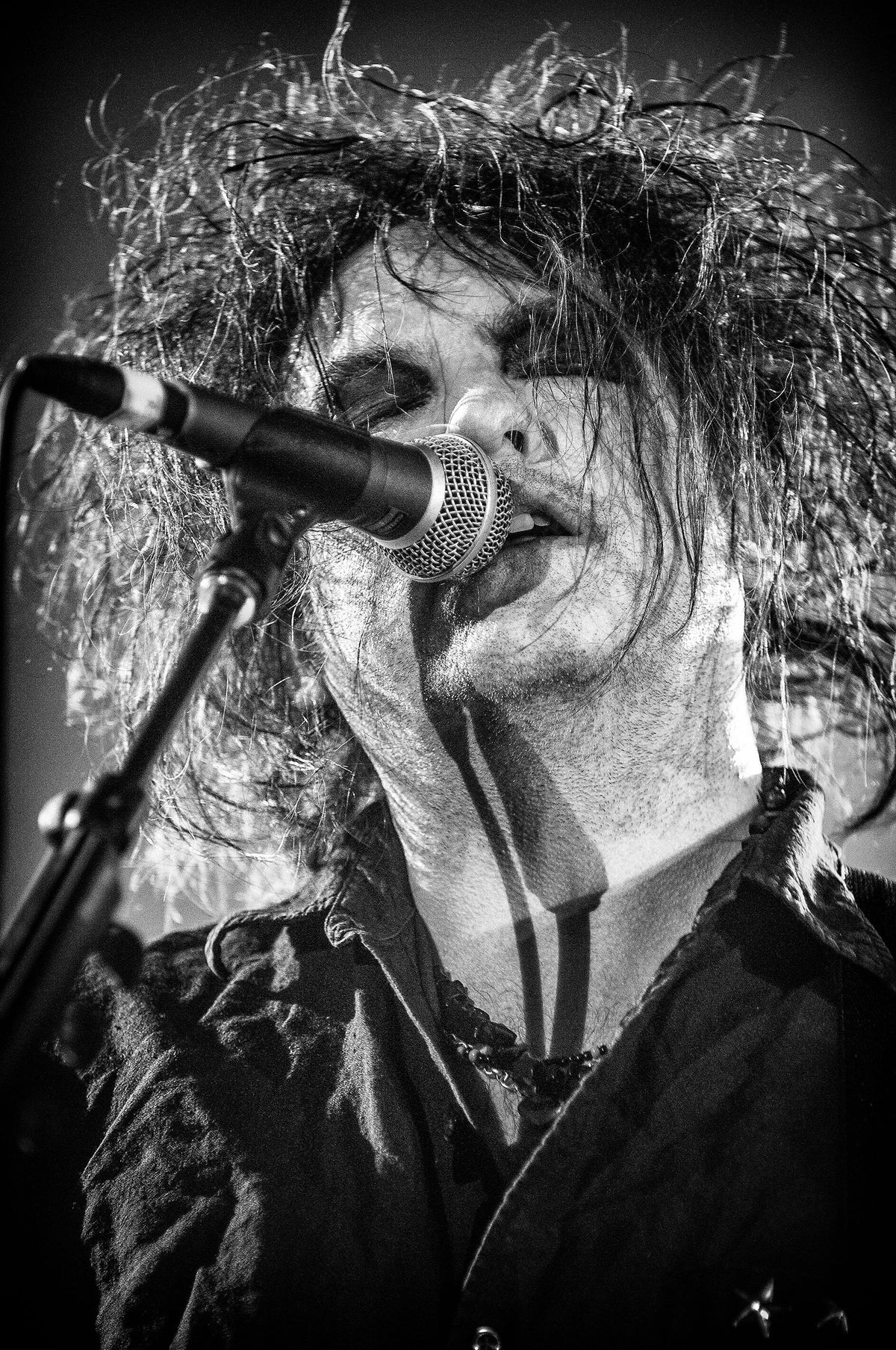 Close-up of Robert Smith singing at the microphone at Shoreline Amphitheatre, Mountain View, California, 2007, photographed by Jérôme Brunet.