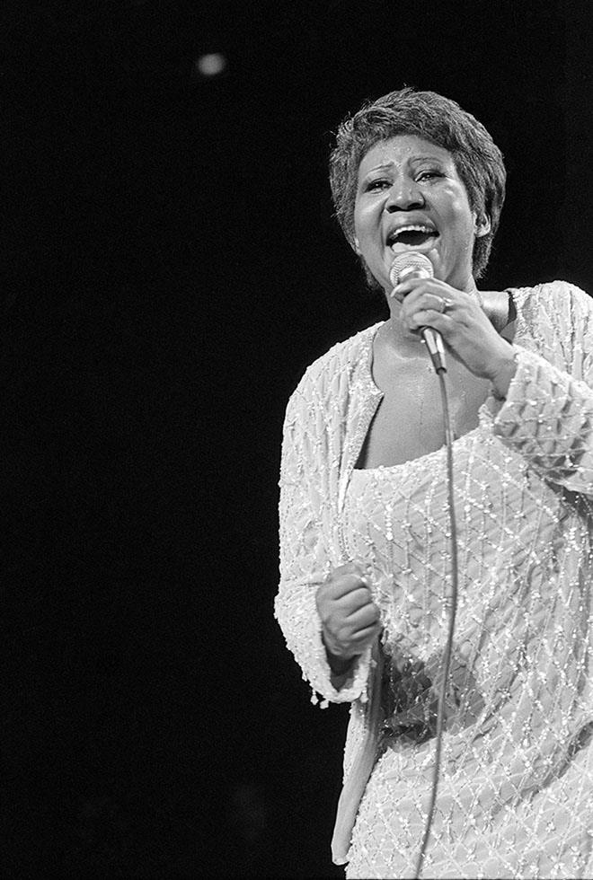 Aretha Franklin singing at the microphone in a beaded gown, New York, photographed by Charlyn Zlotnik, 1982.