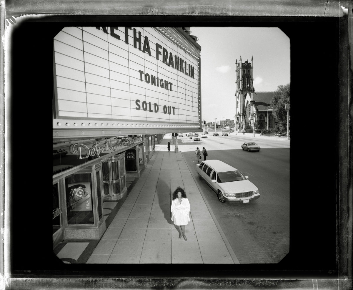 Aretha Franklin stands beneath a theatre marquee bearing her name and the words “Sold Out.” Photograph by Timothy White, Detroit, Michigan, 1996.