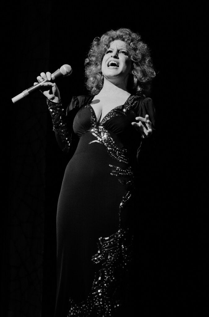 Bette Midler singing in a black sequined gown, in black and white, 1982, photographed by Lynn Goldsmith.