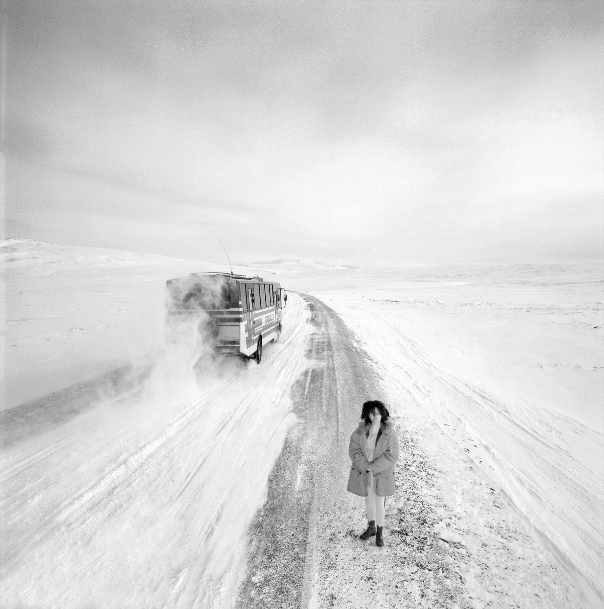 A wide expanse of snow surrounds Björk, whose small figure anchors this open landscape. Photograph by Timothy White, Reykjavík, Iceland, 1988.