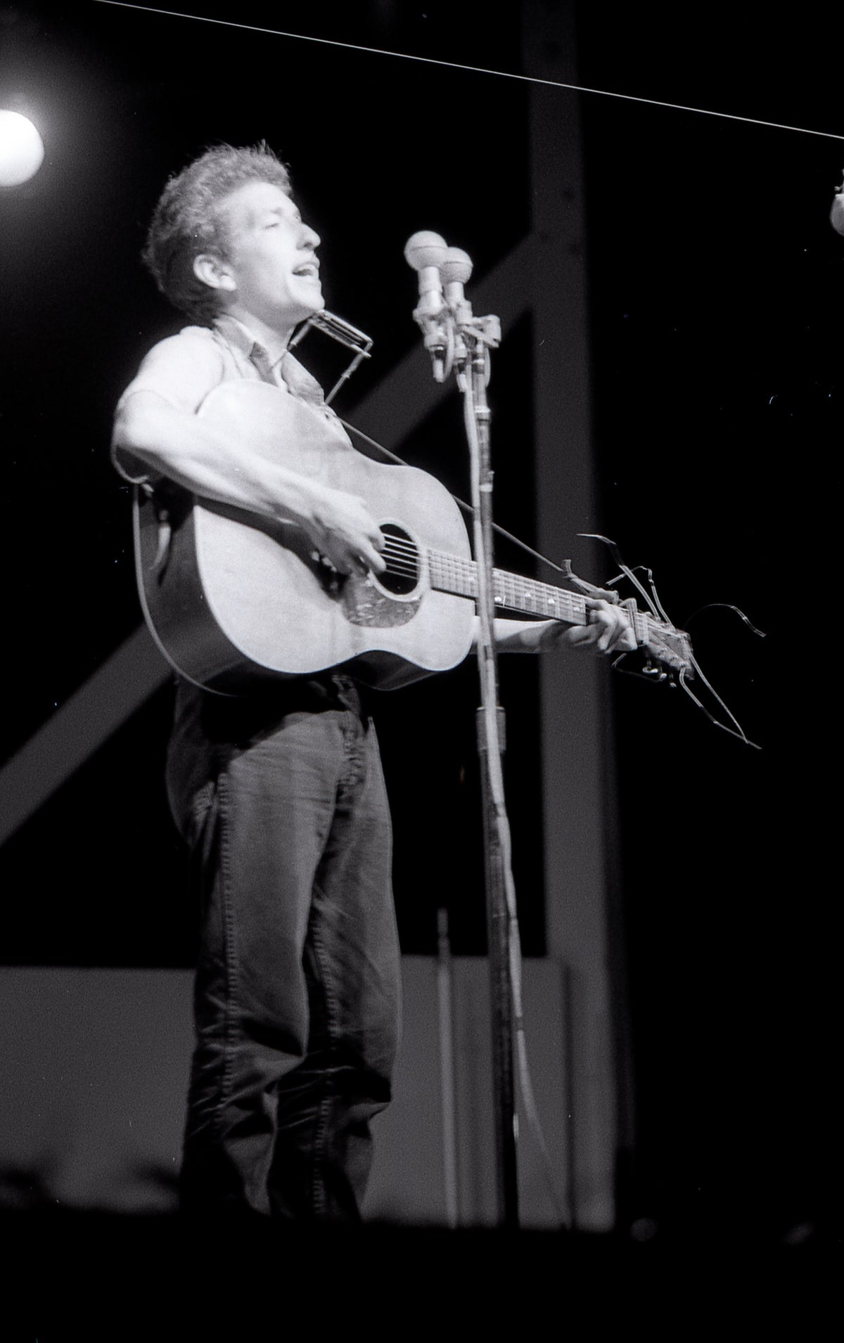 Bob Dylan Standing at the Microphone, Newport Folk Festival, Newport, Rhode Island, July 1963; photograph by John Byrne Cooke.