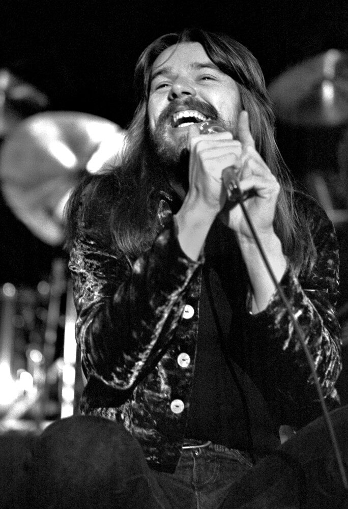 Bob Seger singing with eyes closed, in black and white, 1977, photographed by Lynn Goldsmith.