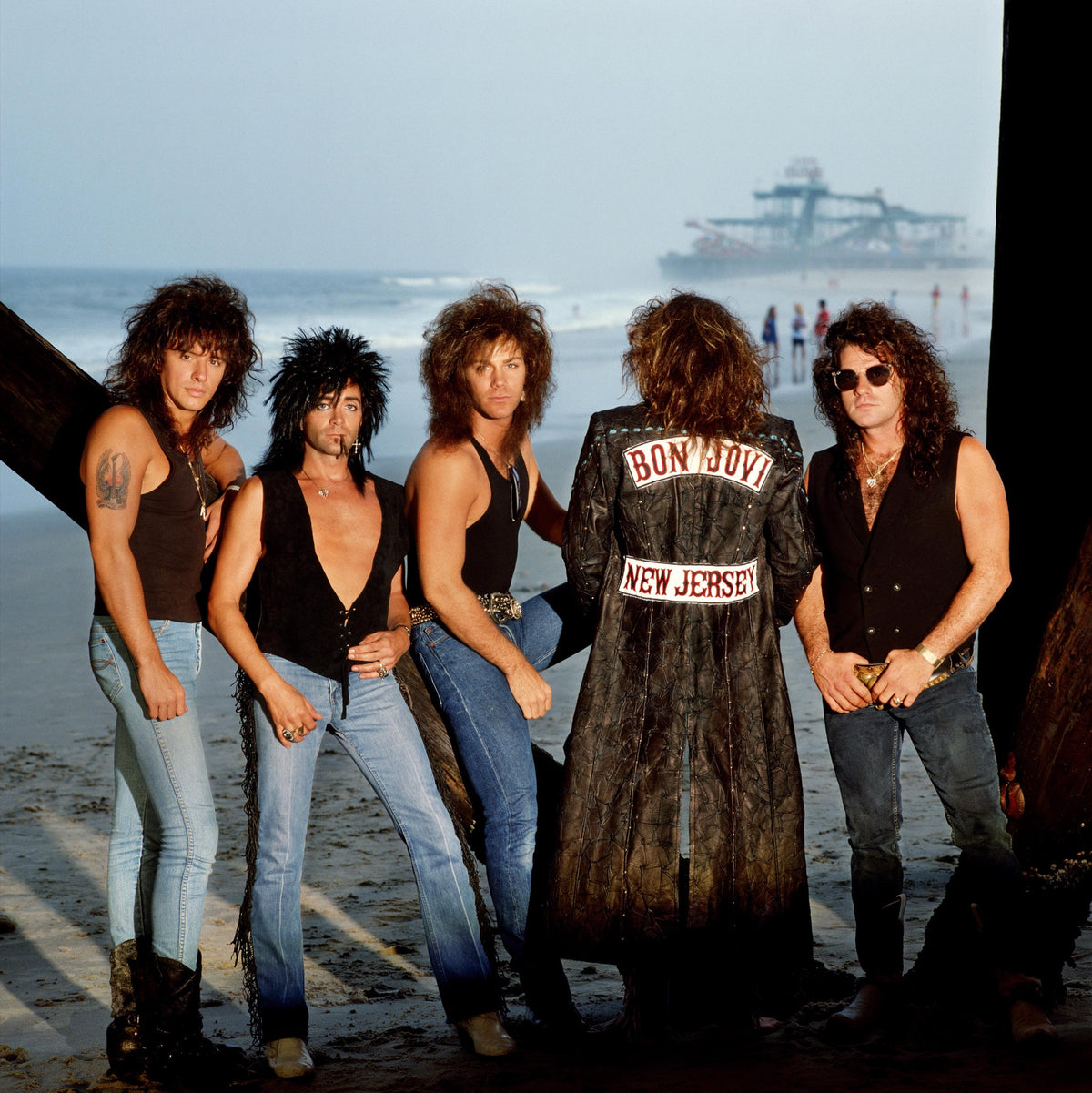 Bon Jovi poses beside the water with a pier visible in the distance. Photograph by Timothy White, Seaside Heights, New Jersey, 1988.