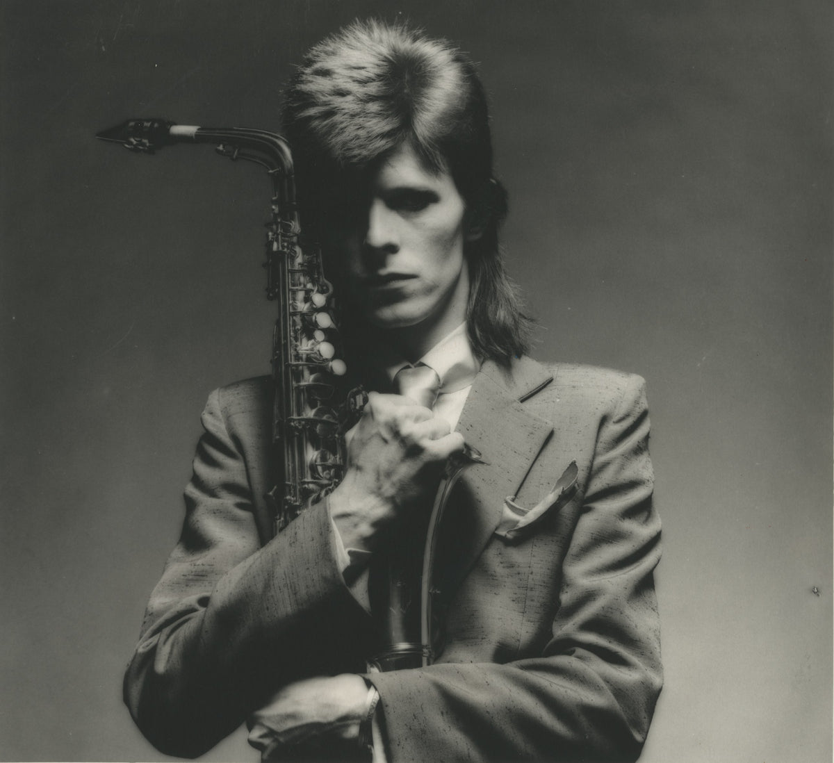 David Bowie in close-up with a saxophone, 1973 Pin Ups Sax Series, photographed by Mick Rock. Unique vintage gelatin silver print.