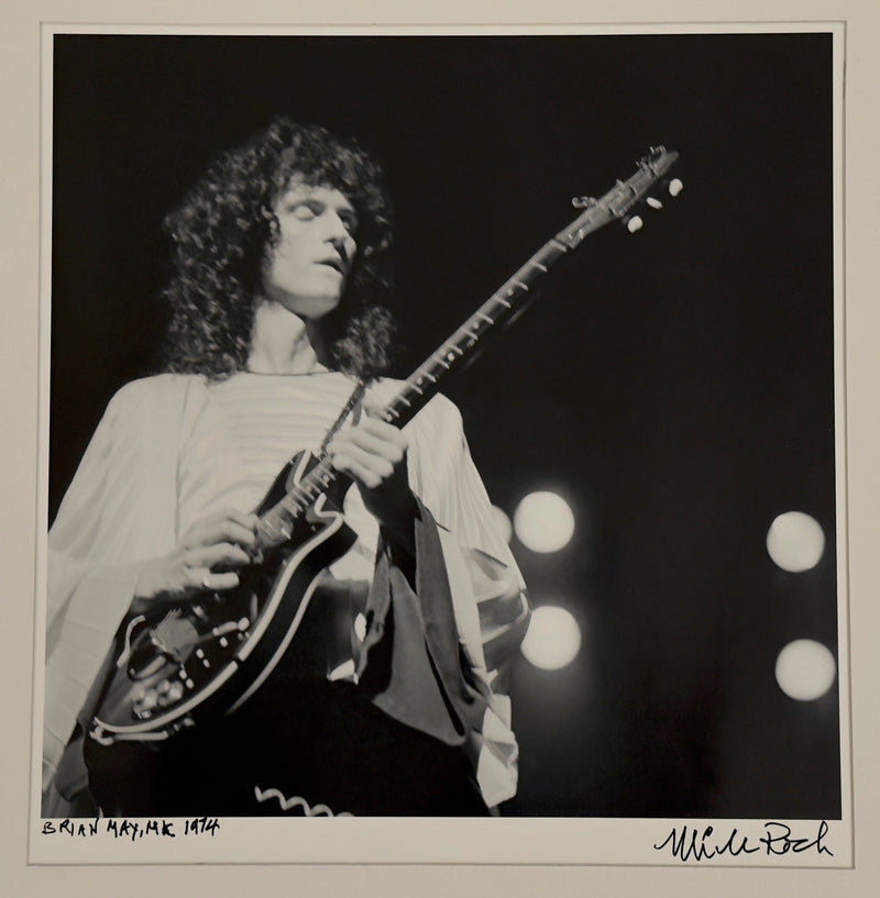 Brian May performing with guitar in the UK, 1974, hand-titled and signed by Mick Rock.