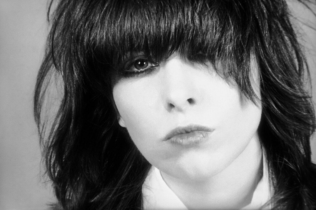 Close studio portrait of Chrissie Hynde, in black and white, 1980, photographed by Lynn Goldsmith.