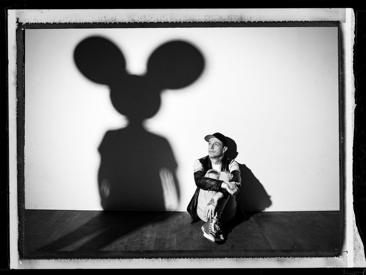 deadmau5 sits beneath the oversized shadow of a mouse-eared silhouette cast onto the wall. Photograph by Timothy White, Los Angeles, California, 2021.