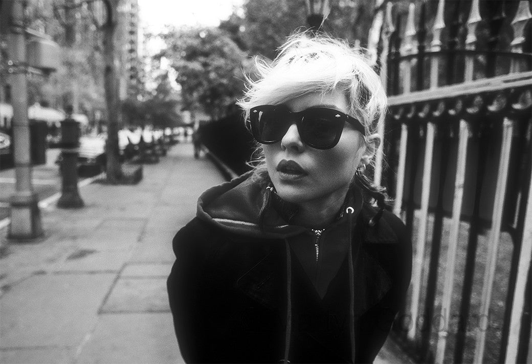 Debbie Harry in dark sunglasses and a hooded jacket beside the Gramercy Park railings, New York City, black-and-white photograph by Martyn Goddard, 1978.