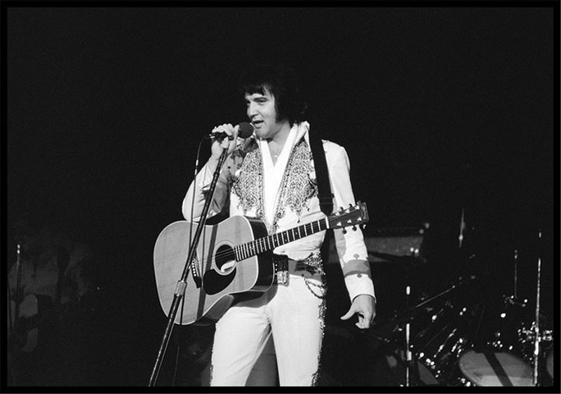 Elvis Presley singing at the microphone with an acoustic guitar, photographed by Charlyn Zlotnik, 1977.