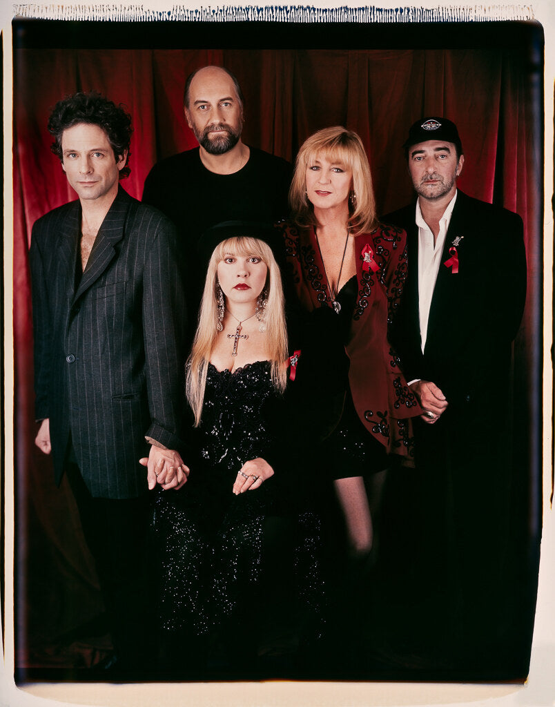 Fleetwood Mac group portrait against a dark red backdrop, in color, 1993, photographed by Lynn Goldsmith.