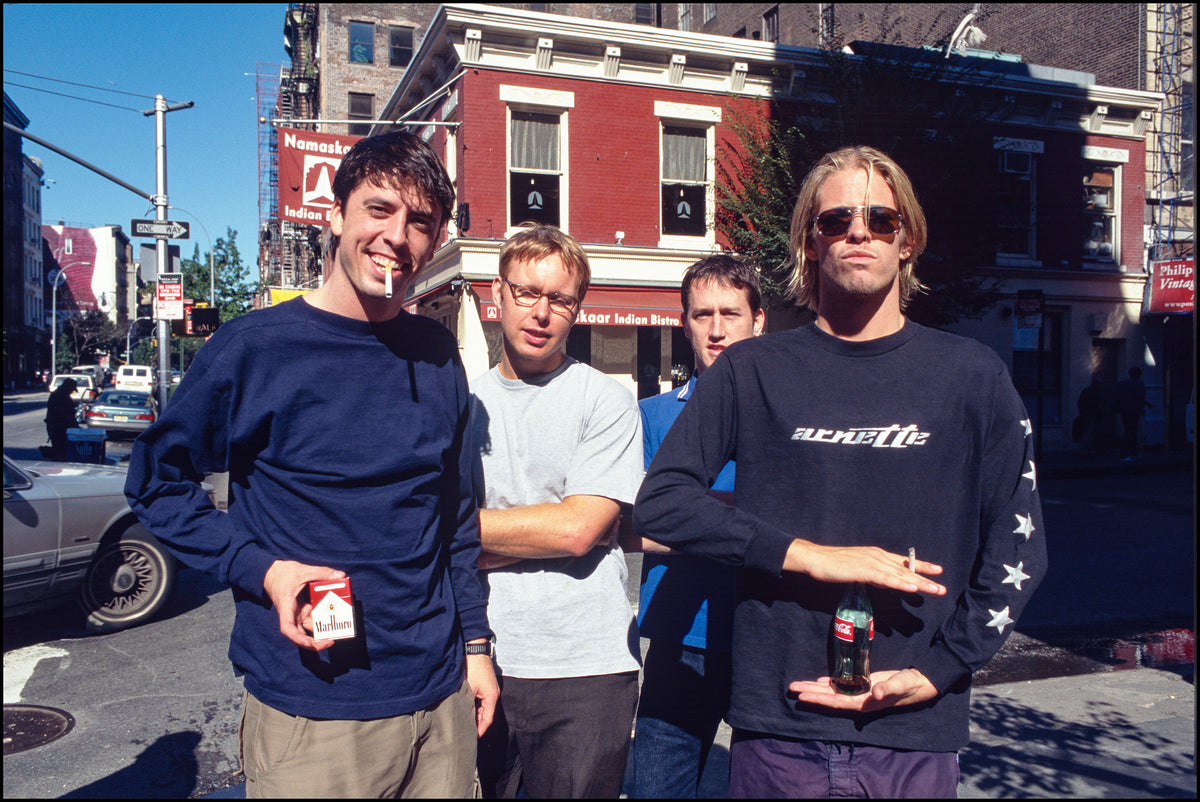 Foo Fighters standing together on a sunny street corner on West Broadway, New York City, 1999, photographed in color by David Corio.