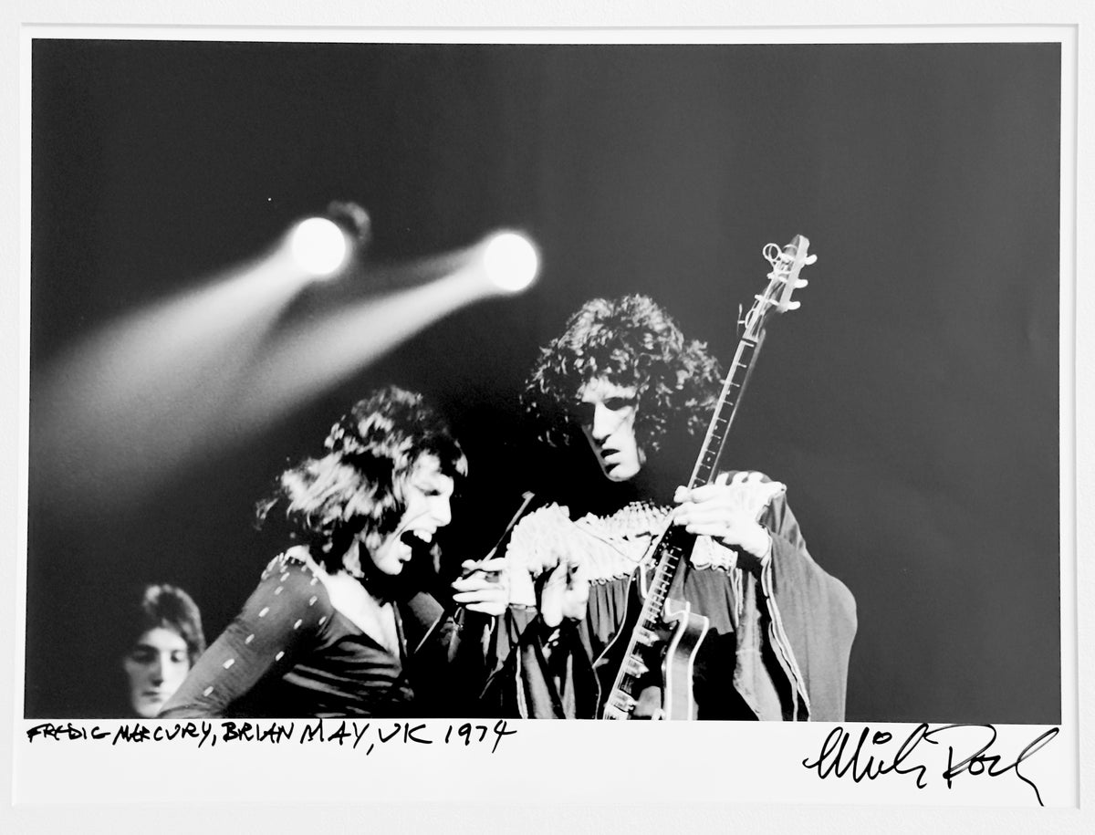 Freddie Mercury and Brian May of Queen sharing the stage in the UK, 1974 — photograph by Mick Rock, a signed, hand-titled late print.