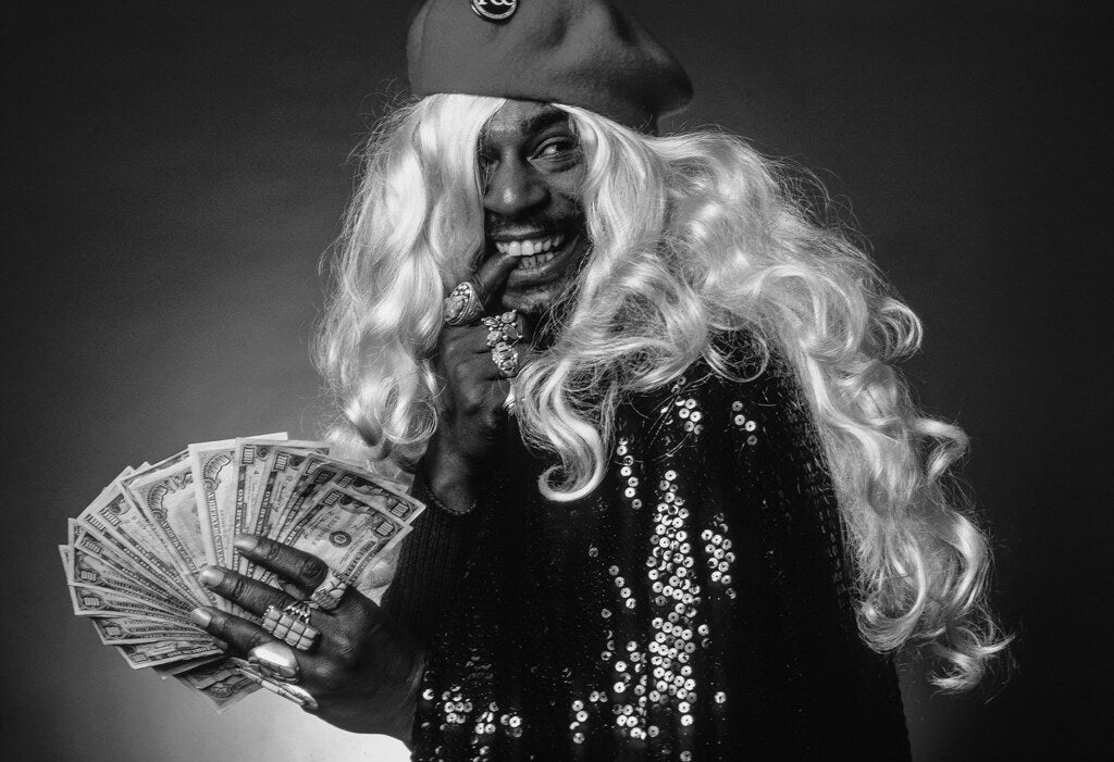 George Clinton in a blond wig fanning a handful of dollar bills, 1980, photographed by Lynn Goldsmith.