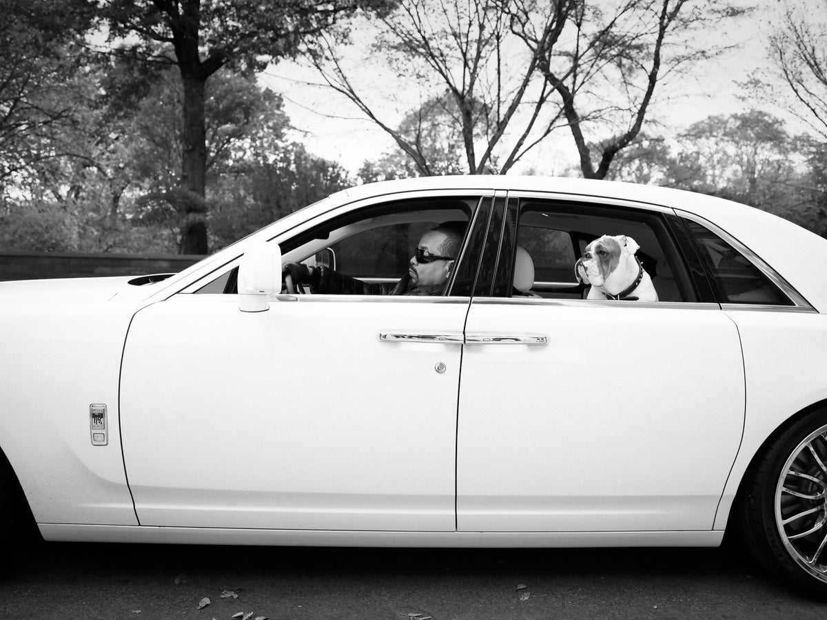 Ice-T is seen through the window of a white Rolls-Royce, with a dog beside him. Photograph by Timothy White, New York City, 2011.