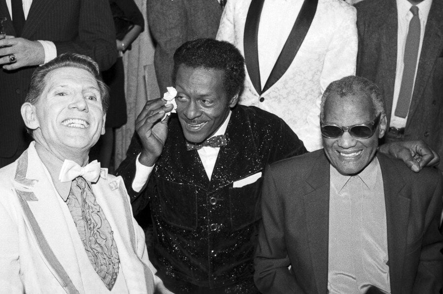 Jerry Lee Lewis, Chuck Berry and Ray Charles laughing together, in black and white, 1986, photographed by Lynn Goldsmith.