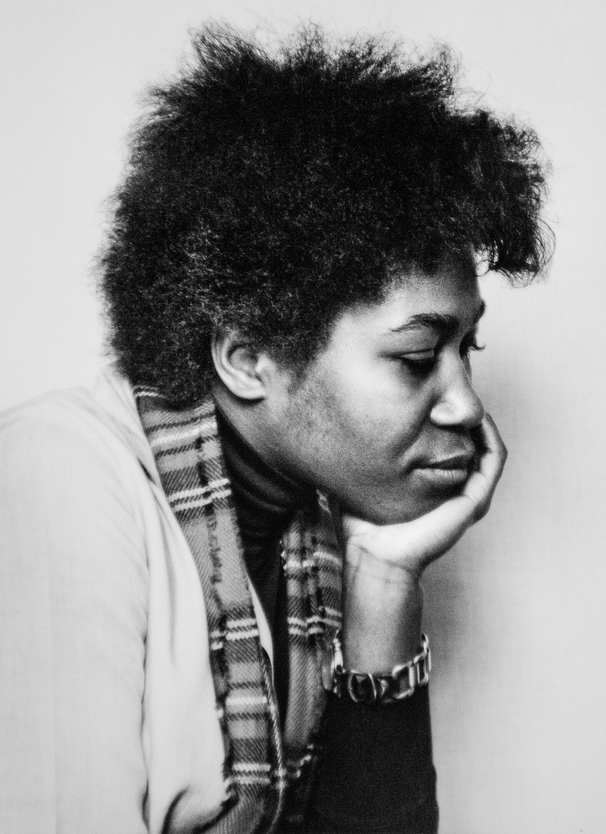 Joan Armatrading resting her chin on her hand, in black and white, 1977, photographed by Lynn Goldsmith.