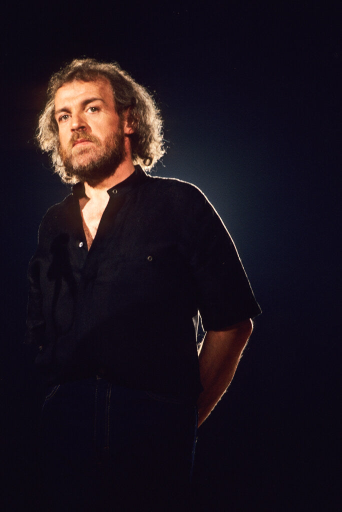 Joe Cocker against a deep blue background, in color, 1982, photographed by Lynn Goldsmith.