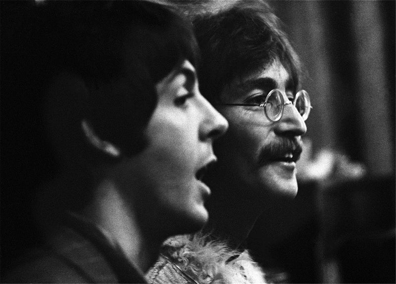 John Lennon and Paul McCartney of The Beatles at a microphone, 1967, photographed by Barrie Wentzell.