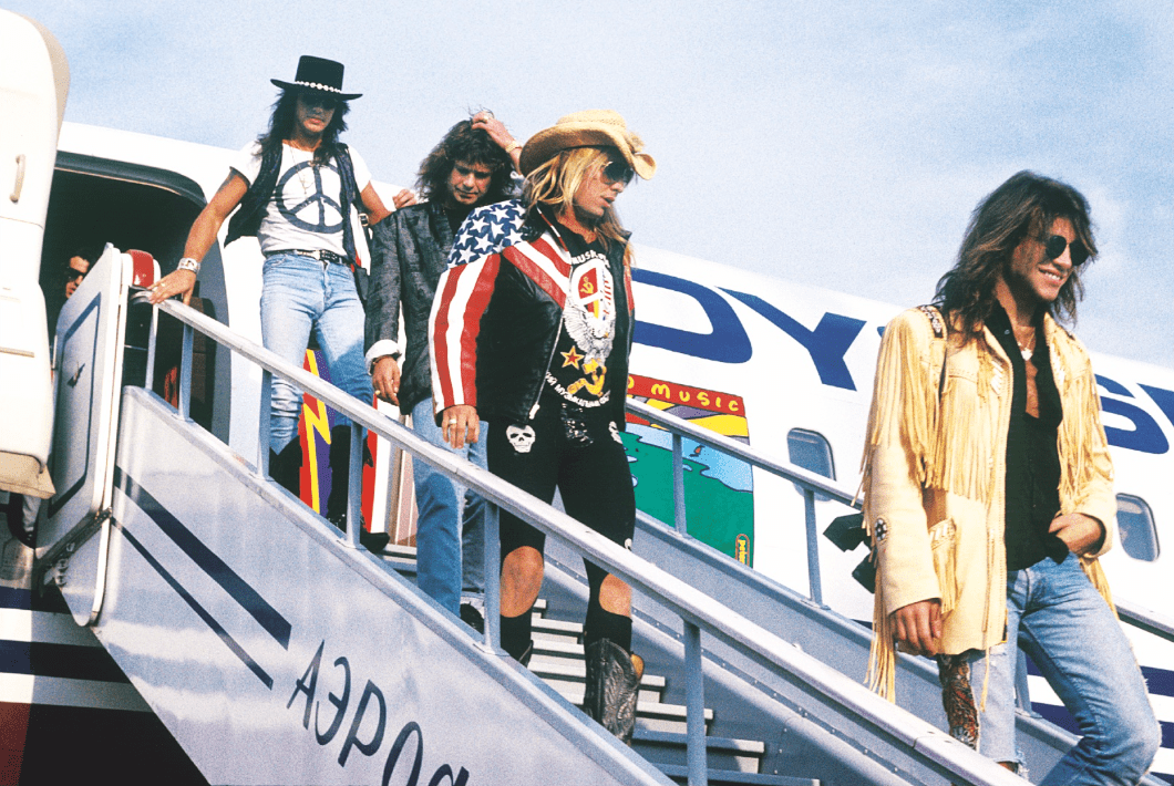 Jon Bon Jovi, Vince Neil, Ozzy Osbourne and Richie Sambora exiting the plane in Moscow, 1989, photographed by Mark Weiss.