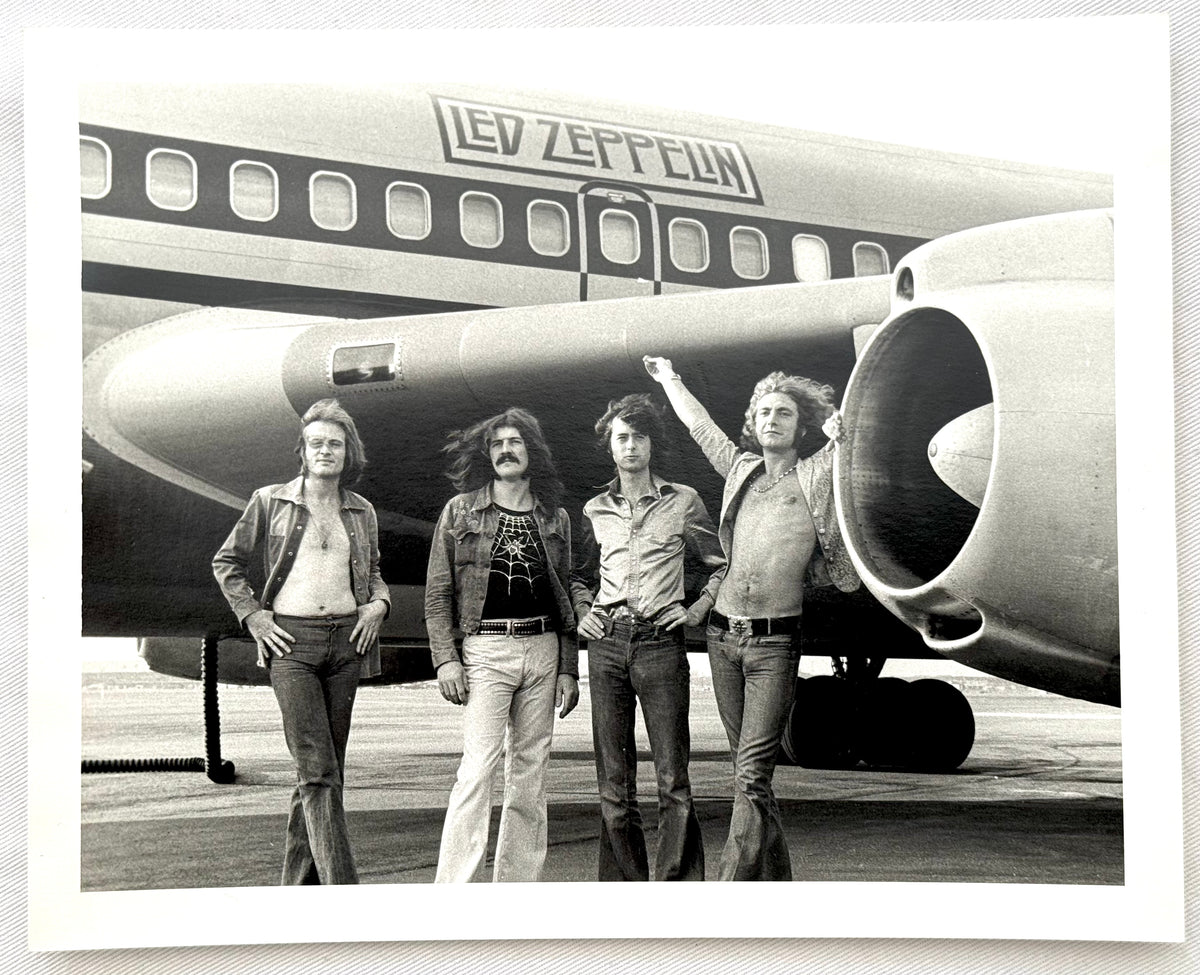 Original vintage gelatin silver print of Led Zeppelin in front of their tour plane, the Starship, New York City, 1973, photographed by Bob Gruen.