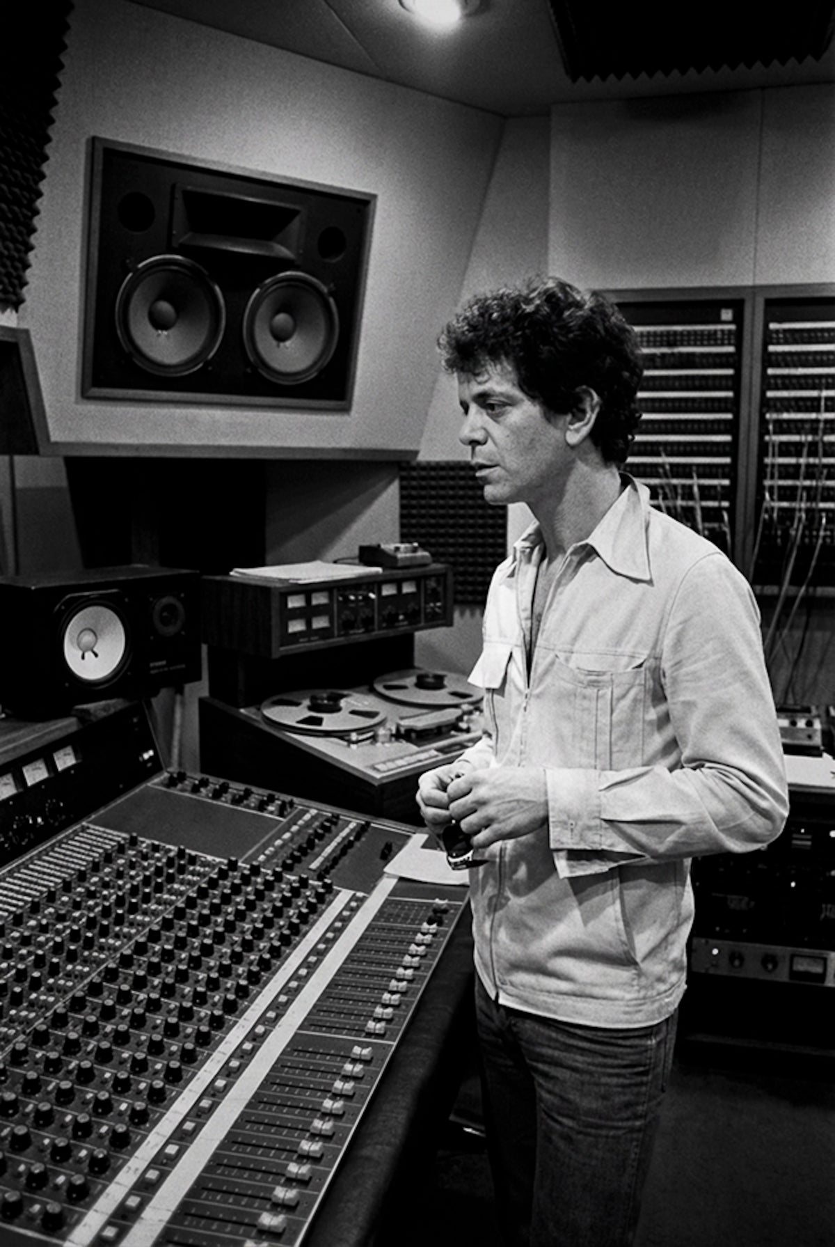 Lou Reed standing at the mixing console in a recording studio, 1977, photographed by Lynn Goldsmith.