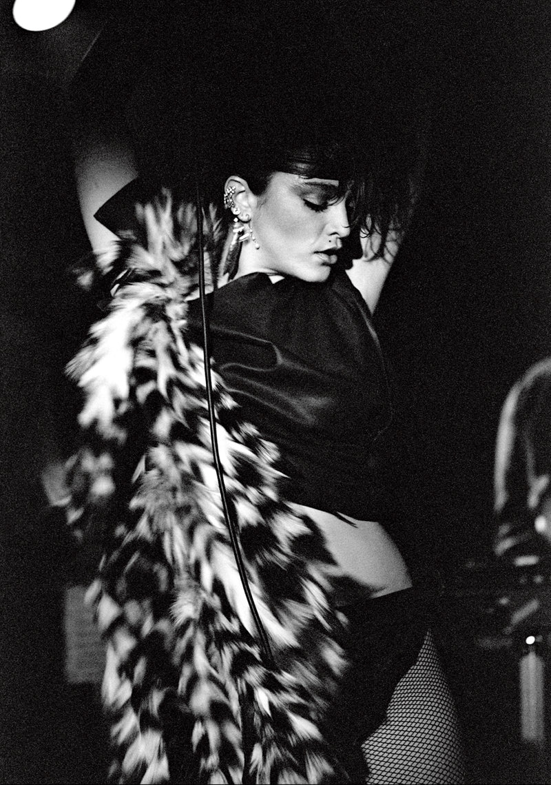 Madonna, backstage portrait wearing a feather boa, photographed by George DuBose.