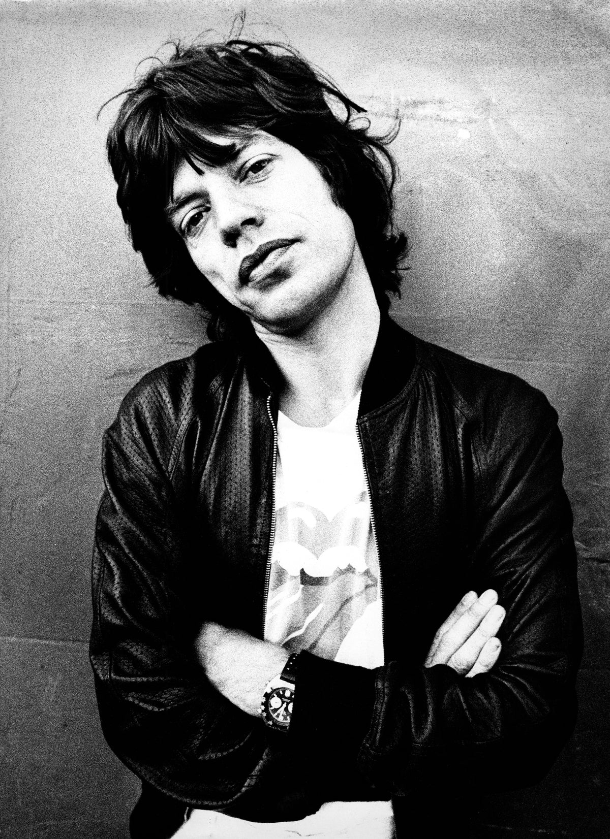 Mick Jagger posed with his arms crossed against a plain wall in 1975. Photograph by Gijsbert Hanekroot.