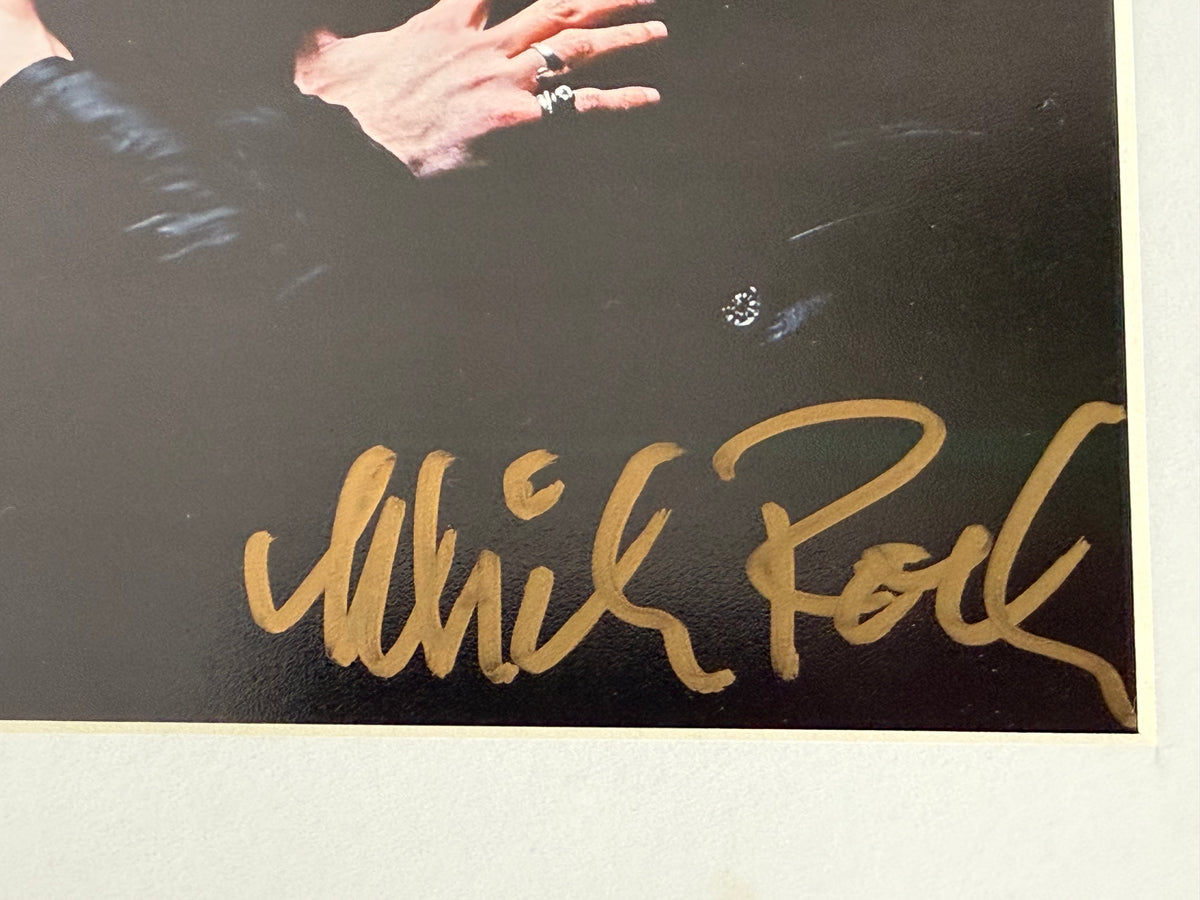 A close-up of Mick Rock's signature in gold. 