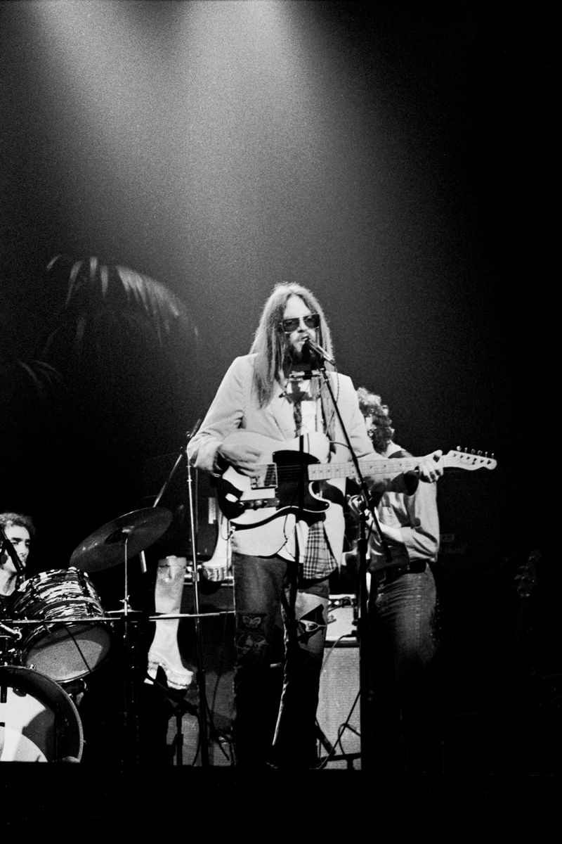 Neil Young performing with an electric guitar at the microphone in 1973. Photograph by Gijsbert Hanekroot.