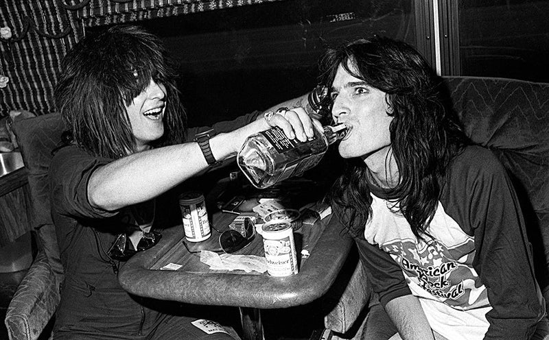 Nikki Sixx and Tommy Lee of Motley Crue on the tour bus during the Shout at the Devil Tour, 1984, photographed by Mark Weiss.