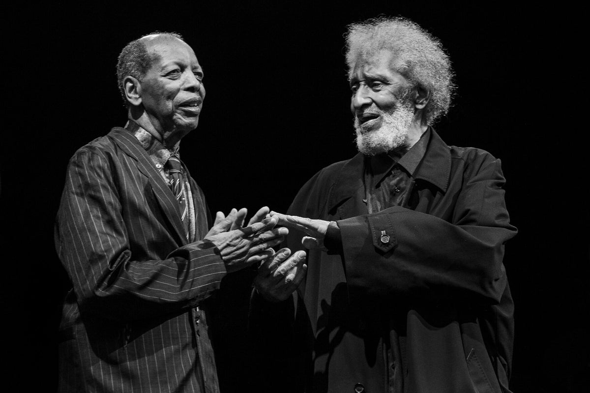 Ornette Coleman and Sonny Rollins clasping hands, in black and white, 2014, photographed by Lynn Goldsmith.